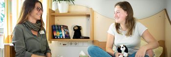 Zwei Mädchen sitzen gemütlich zusammen und unterhalten sich