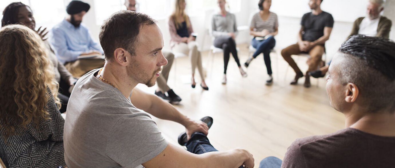 In der Gruppentherapie sitzen Männer und Frauen im Kreis