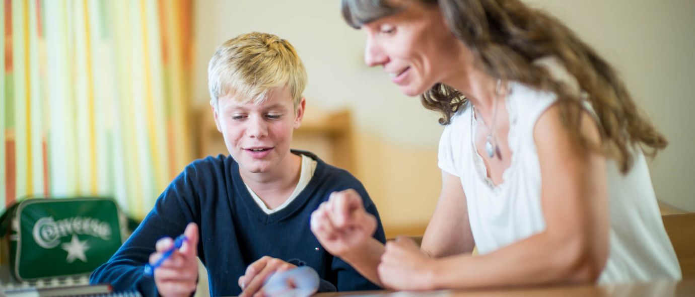 Ein Junge übt mit einer Therapeutin bei der Sprachtherapie