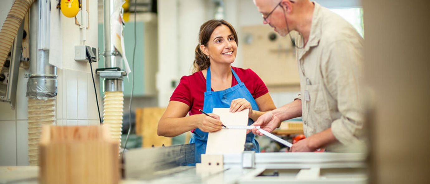 Eine Patientin und ein Ergotherapeut arbeiten in der Werkstatt