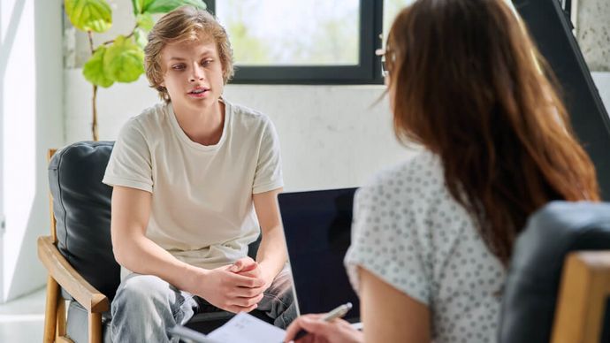 Ein Teenager ist zu Hause im Gespräch mit einer Therapeutin