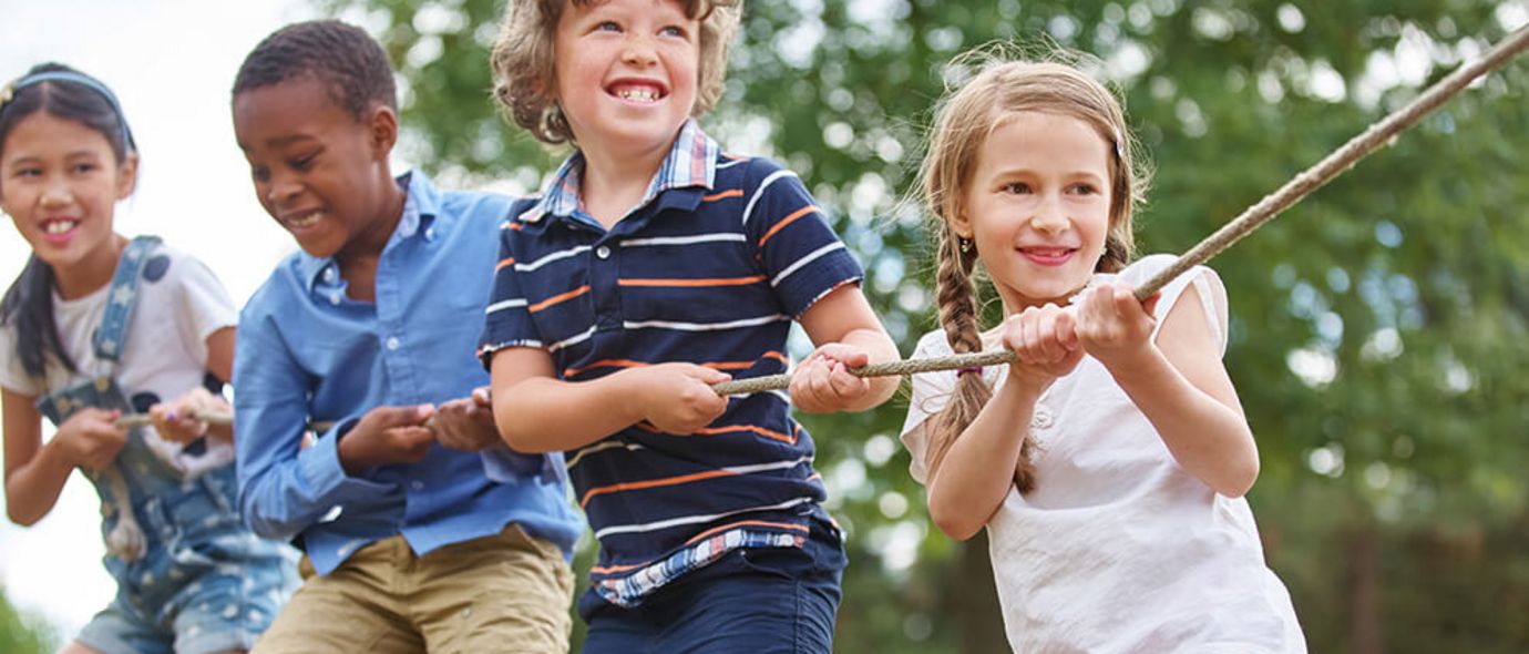 Vier Kinder ziehen an einem Seil