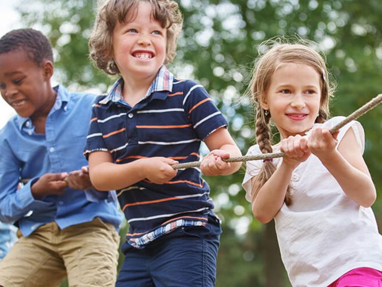 Vier Kinder ziehen an einem Seil